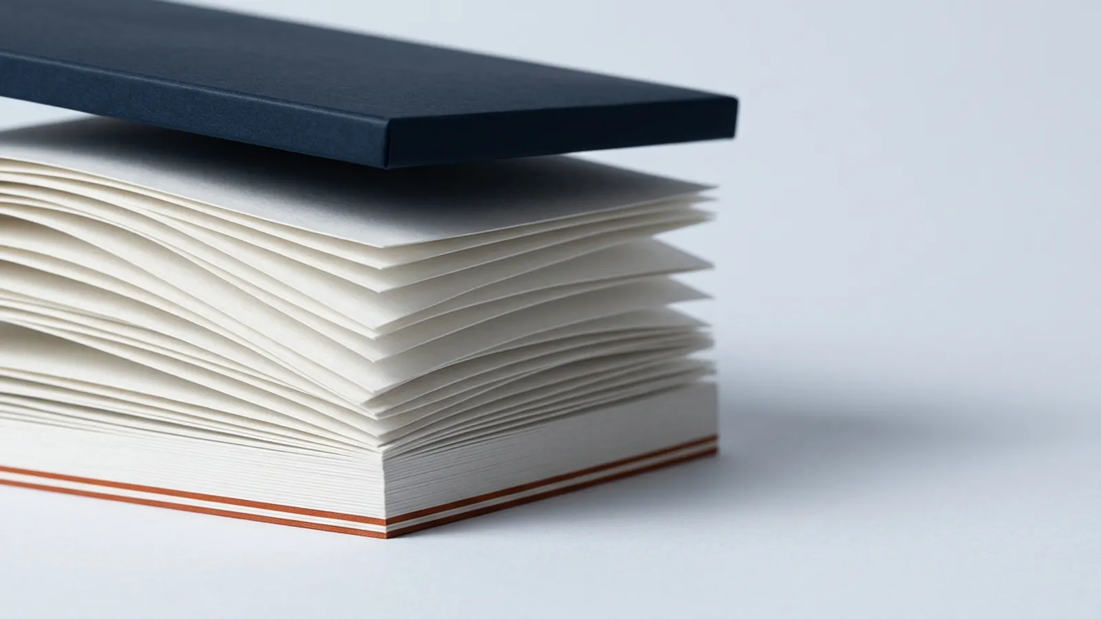 A tall stack of paper being compressed into a single thin layer by a heavy slab.