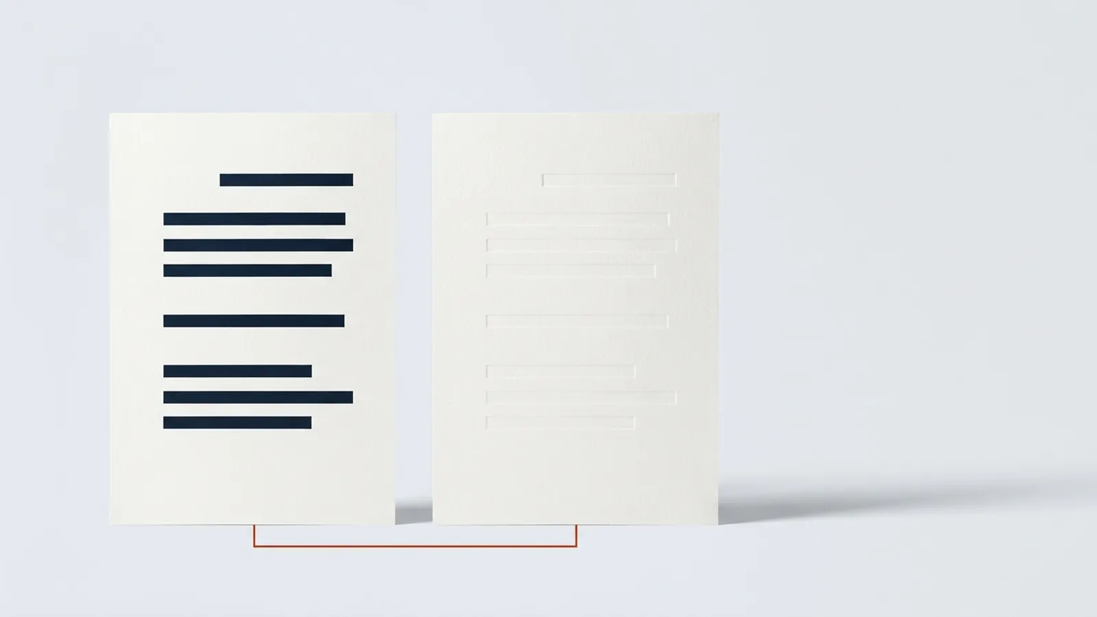 Two identical sheets of paper stand side by side, one with dark ink bands and the other completely blank.