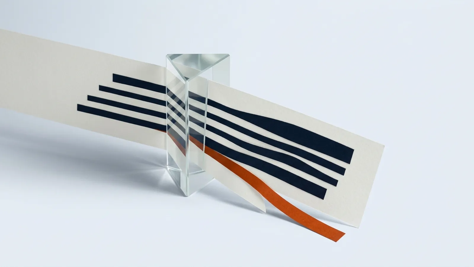 A sheet of paper passes through a glass prism, stretching and distorting its printed lines.